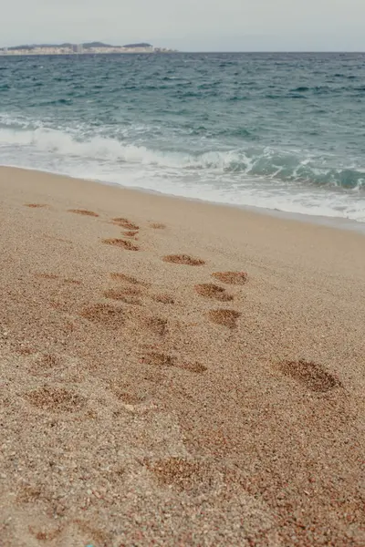 Costa Brava 'da sakin suları olan bir sahilde kumsalda ayak sesleri.