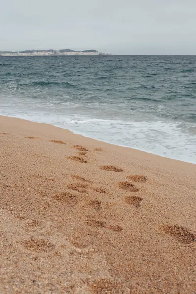 Costa Brava 'da sakin suları olan bir sahilde kumsalda ayak sesleri.
