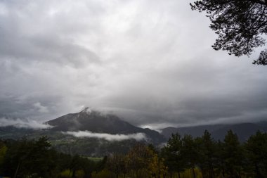 Pirenes dağlarındaki bir vadide dağ zirvesini kaplayan fırtınalı kış bulutları.