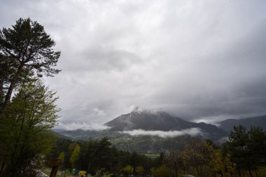 Pirenes dağlarındaki bir vadide dağ zirvesini kaplayan fırtınalı kış bulutları.