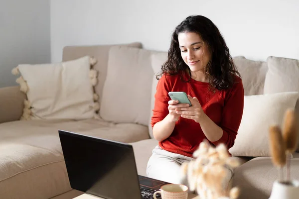 Jovem Mulher Feliz Usando Telefone Computador Sentado Sofá Casa — Fotografia de Stock