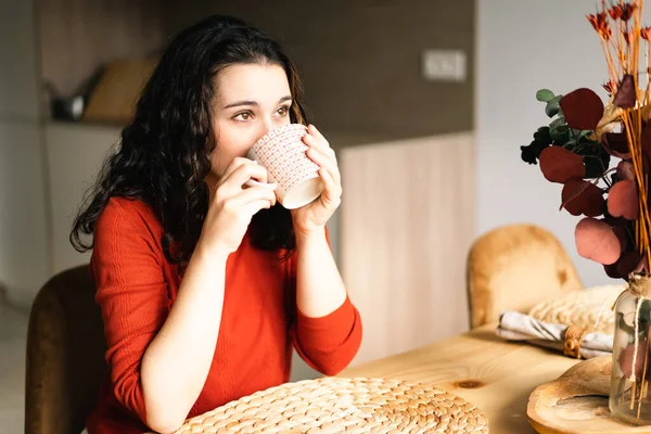 Młoda Kobieta Pije Kawę Siedząc Przy Stole Kuchni — Zdjęcie stockowe