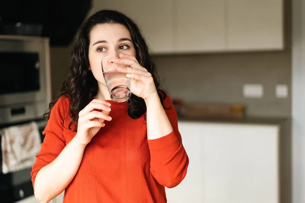 Joven Morena Suéter Naranja Bebiendo Agua Dulce Cocina —  Fotos de Stock
