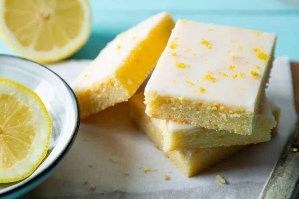 Пирожные Лимоном Лимонной Глазурью Изюминка Бумаге Выпечки Аквамариновом Фоне — стоковое фото
