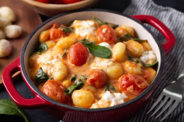 Kremalı domates soslu gnocchi güvecini bebek ıspanağı ve erimiş mozzarella ile kapat.