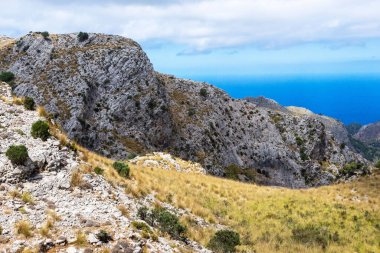 Mallorca adasındaki resim gibi bir manzara. Okyanusla kaplı dağ sırası bulutlu bir gökyüzünün altında. 