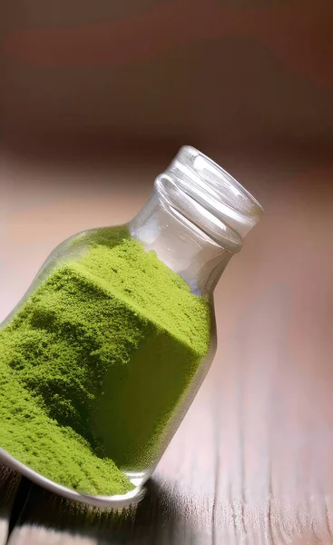 green tea powder in a glass jar on a wooden background