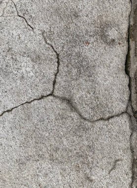 Beton bir duvardaki çatlağın yakın plan fotoğrafı, çatlaklar ve çatlaklarla donatılmış beton yüzey.