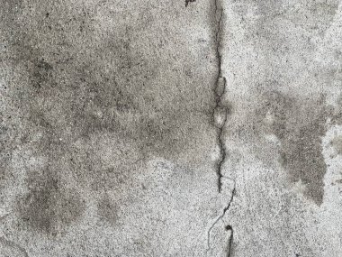 Çimento duvarının kenarında duran bir yangın musluğunun fotografı. Çatlak ve çatlaklarla kaplı beton duvarlar.