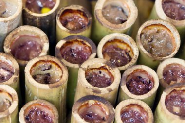 Masada oturan bir grup muzun fotoğrafı, bir masanın üzerinde duran bir sürü yemek çubuğu var.