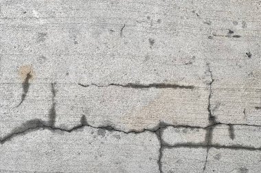 Kaldırımda bir yangın musluğunun fotoğrafı betonda çatlak, beton duvarda çatlaklar ve çatlaklar var.