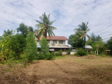 Bahçesinde büyük beyaz bir ev ve birkaç ağaç olan manastır..