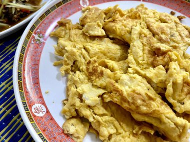 Masada bir tabak yemek, bir kase salata ve bir tabak kızarmış yumurta..