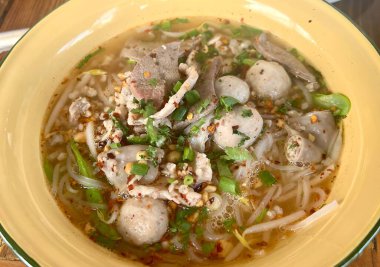 İçinde köfte, erişte ve sebze olan çorba kasesi..