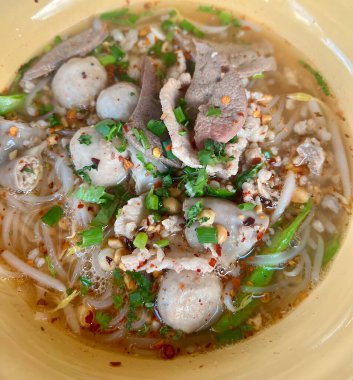 İçinde et, erişte ve sebze olan çorba kasesi..