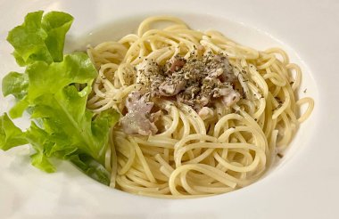 Bir salata ve çatallı Carbonara fotoğrafı..