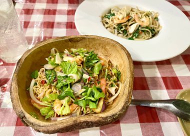 Bir tabak yemeğin ve bir kase eriştenin fotoğrafı..