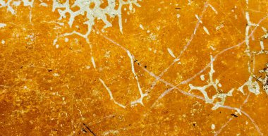 Beyaz boyalı sarı bir duvarın fotoğrafı. Duvarda beyaz çizgiler olan sarı boya..