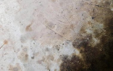 Kirli zeminin, beyaz ve kahverengi lekeli, paslı ve beyaz duvarlı kirli beton yüzeyi..