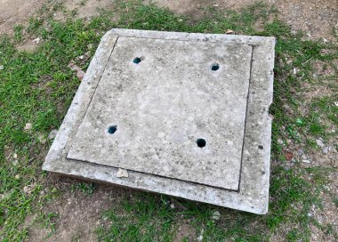 Yerde delikleri olan bir beton kutunun fotoğrafı. Yerde delikleri olan bir beton kutu var..