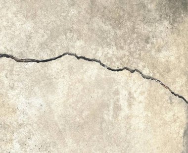 Betondaki çatlağın fotoğrafı, betonda bir çatlak, betonda çatlak ve yangın musluğu olduğunu gösteriyor..