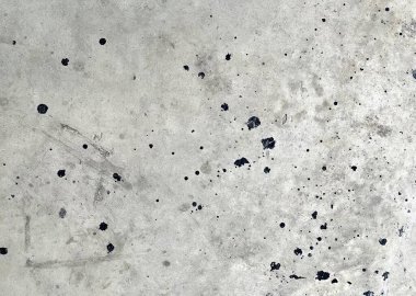 Beton bir yüzey üzerinde beton bir zeminde kaykay süren ve beyaz bir arka planı olan bir kişinin fotoğrafı..