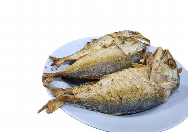 白いテーブルの上の魚のプレートの写真 白いテーブルの上のプレート上の2匹の魚があります — ストック写真