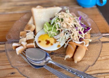 Çatal ve kaşıkla bir tabak yemeğin fotoğrafı. Üzerinde çatal ve kaşık olan bir tabak yemek var..