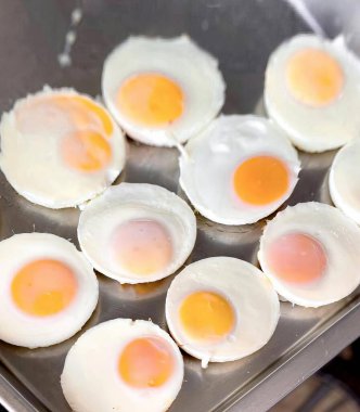 Fırında pişen bir yumurta tavasının fotoğrafı, ocağın tepesinde tavada kızartılan yumurtalar..