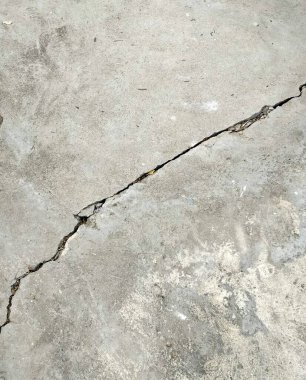 Beton bir yüzeyde kırık bir yangın musluğunun fotoğrafı. Beton zeminde kırık bir yangın musluğu var..