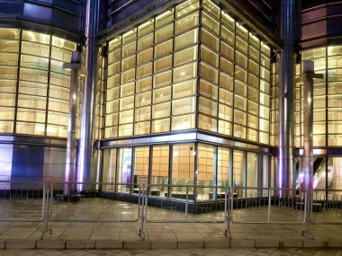 Bir sürü penceresi ve saati olan bir binanın fotoğrafı. Bir sürü penceresi ve saati olan büyük bir bina var..