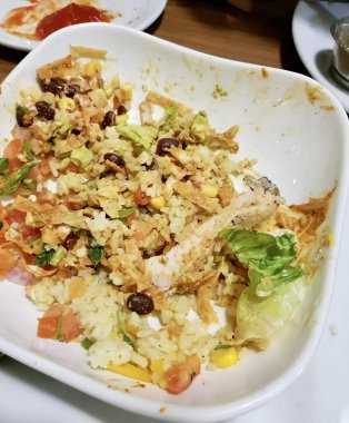 Pirinç ve sebzeli bir tabak yemeğin fotoğrafı. Masanın üzerinde bir tabak yemek var..