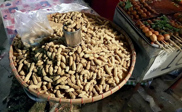 stock image a photography of a basket of peanuts and a basket of chicken, there are many peanuts in a basket on the table.