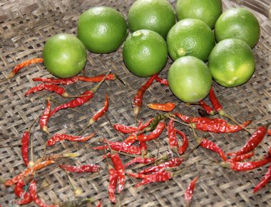 Masada bir sepet limon ve kırmızı biber var. Sepette bir sürü limon ve kırmızı biber var..