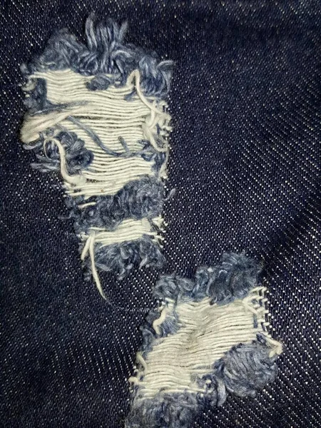 Fotografi Sepasang Celana Jeans Dengan Pinggiran Keributan Dan Lubang Belakang — Stok Foto