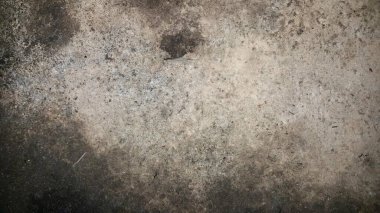 İçinde küçük bir delik olan kirli bir duvarın, ortasında bir delik olan beton bir duvarın fotoğrafı..