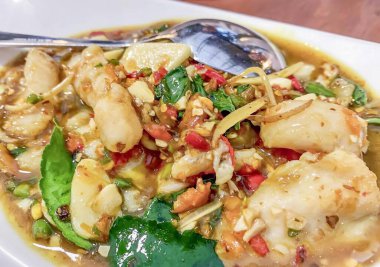 Bir tabak yemeğin bir kaşık ve kaşıkla fotoğrafı, beyaz bir tabak ve bir tabak yemek var..