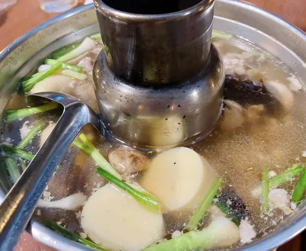 有一壶汤里有勺子和勺子的照片 还有一壶汤里有土豆和芦笋 — 图库照片