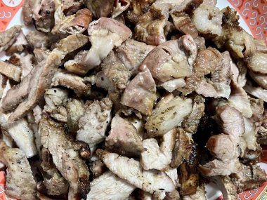 Masanın üzerinde bir tabak et resmi var. Masanın üzerinde kırmızı ve beyaz tabakla bir tabak et var..