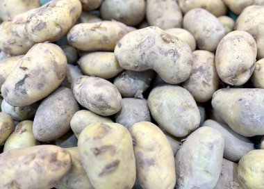 Bir masanın üstünde oturan patates yığınının fotoğrafı, bir masanın üstünde oturan patates yığınının yakın çekimi..