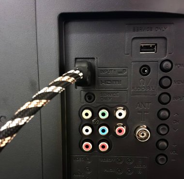 Uzaktan kumandanın kabloyla çekilmiş bir fotoğrafı. Kablosu olan siyah bir kontrol paneli var..