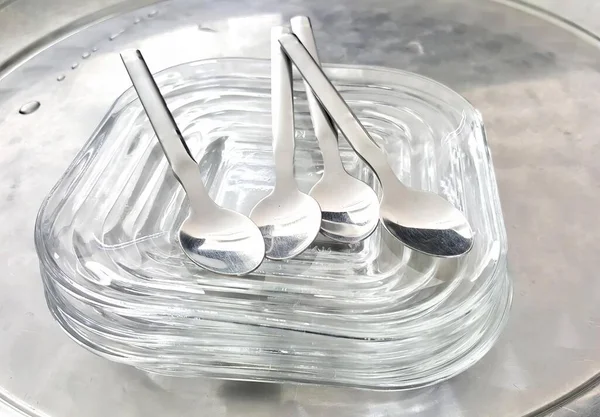 一个装有三个勺子和一个勺子的盘子的照片 在一个透明的容器里有三个勺子和两个勺子 — 图库照片