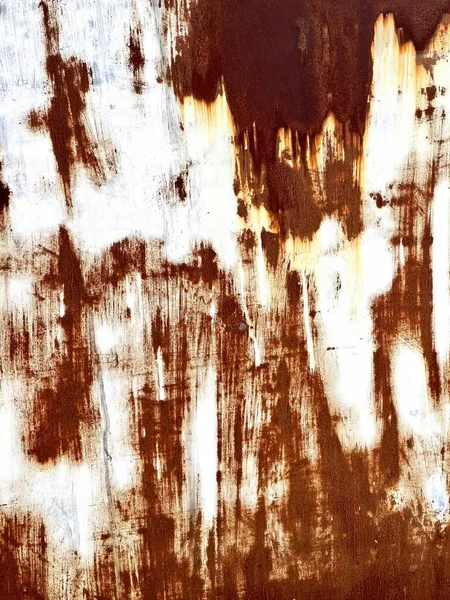 a photography of a rusted wall with a fire hydrant in the middle, wall with rust and paint on it with a fire hydrant.