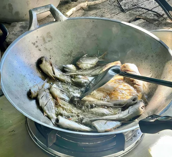 锅里的鱼在炉子上做饭的照片 锅里的鱼在炉子上做饭的照片 — 图库照片