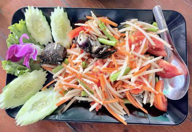 Çatal ve çiçekli bir tabak salata, çatallı bir tabak salata ve masada bir kaşık..