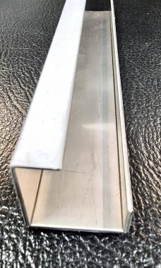 Bir yüzeydeki metal şeridin fotoğrafı, beyaz arkaplanlı siyah bir yüzeydeki metal şerit..