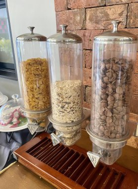 İçinde üç kutu mısır gevreği ve bir tepsi mısır gevreği olan bir tezgahın fotoğrafı..