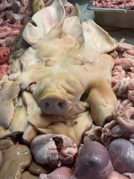 Una Fotografía Montón Carne Con Una Cabeza Cerdo Parte Superior — Foto de Stock