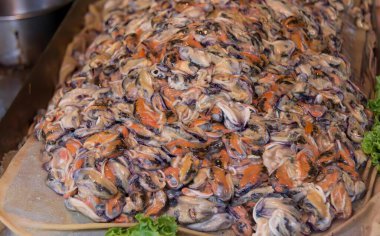 Tavada bir sürü malzeme bulunan büyük bir pizzanın fotoğrafı. Homarus americanus, bir sürü renkli büyük bir mürekkep balığı..