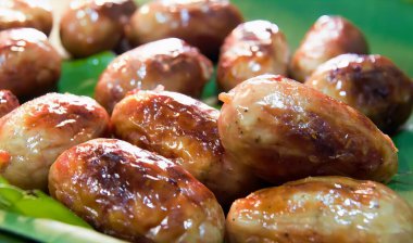 Bir tabak dolusu soslu köfte, yeşil tabakta pişmiş köfte ve yaprak..